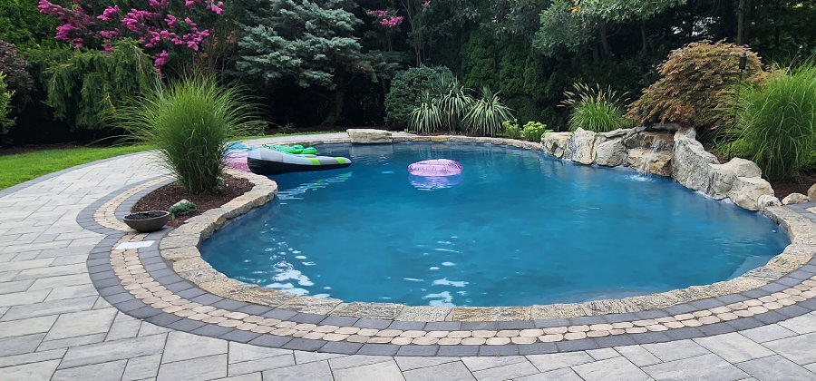 mountain lake pool with cambridge pavers and moss rock waterfall