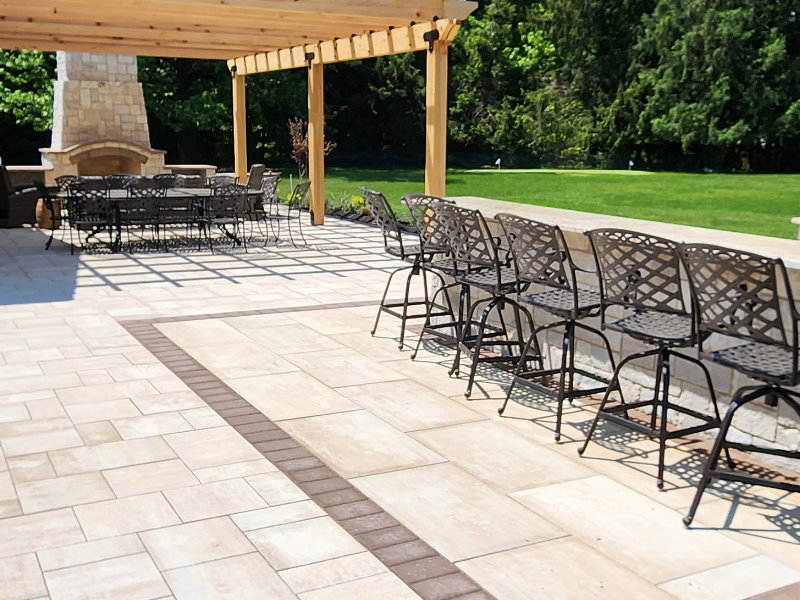 unilock pavers with bar island and fireplace